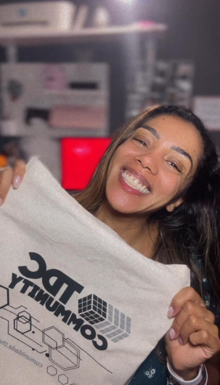Alessandra Nastassja sorrindo e segurando uma sacola da TDC Community